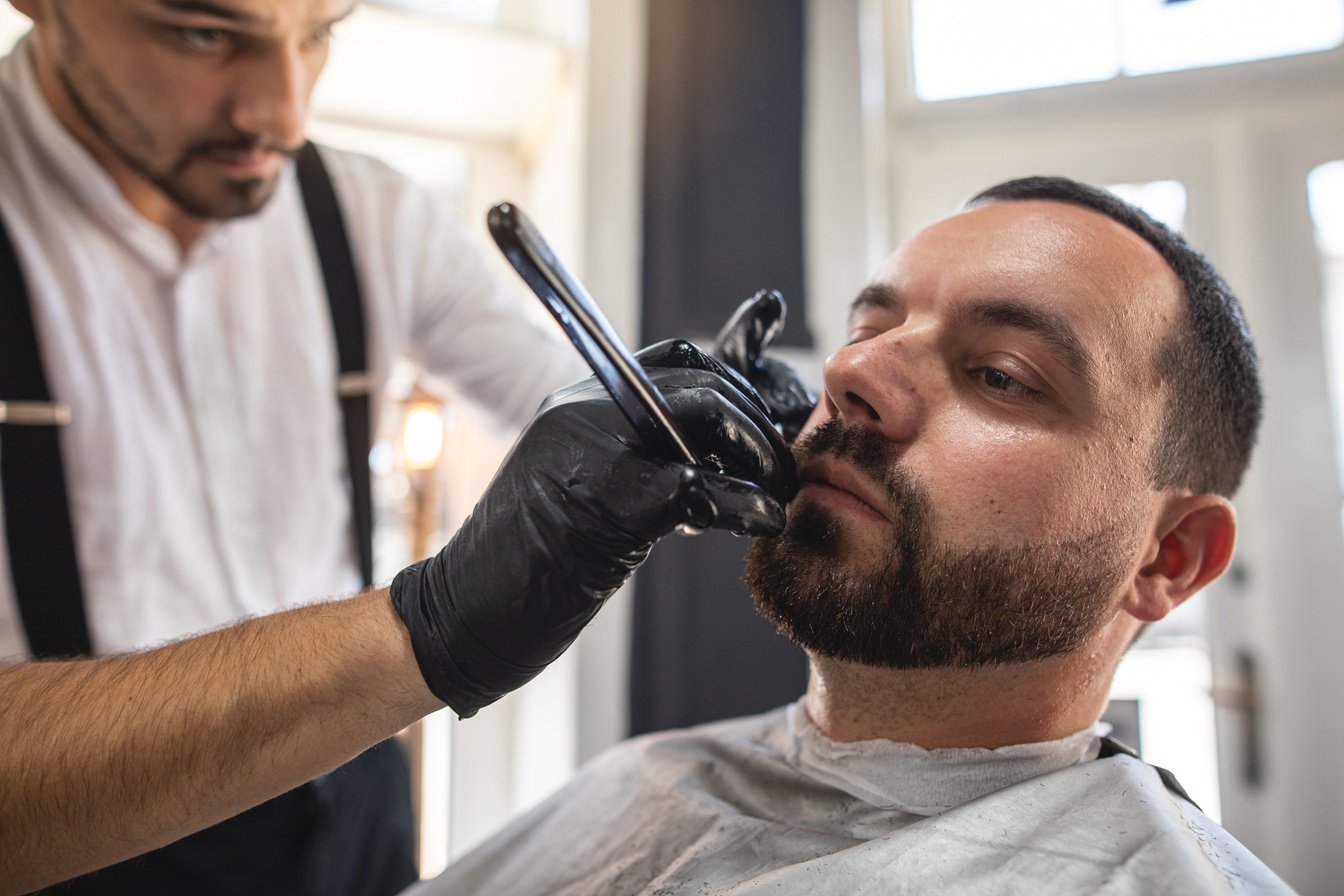 Barber shaping up his customers beard